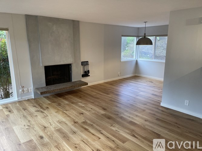 A living room with a fireplace and wooden flooring.