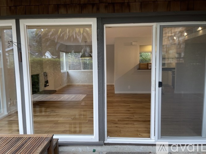 A modern house entrance with a glass door and a wooden floor.