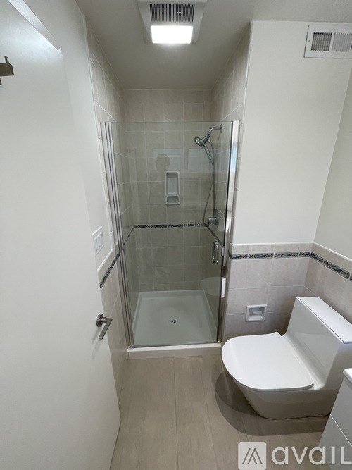 A bathroom with a toilet, sink, and walk-in shower.