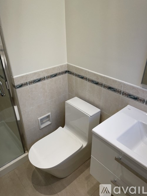 A white toilet and sink in a bathroom.