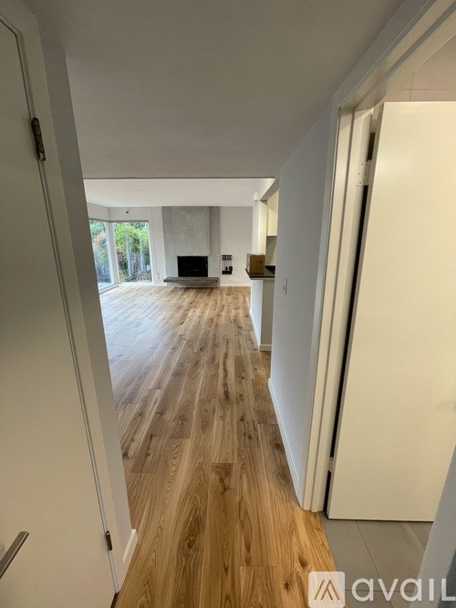 A bathroom with a toilet, sink, mirror, and window.