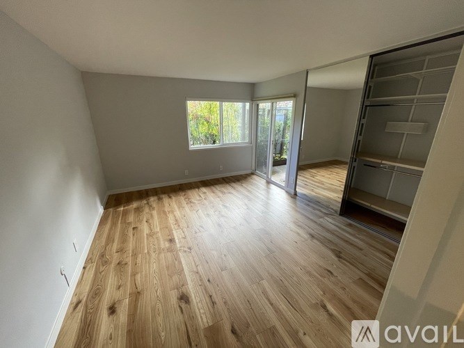 A room with wooden flooring and a large window.