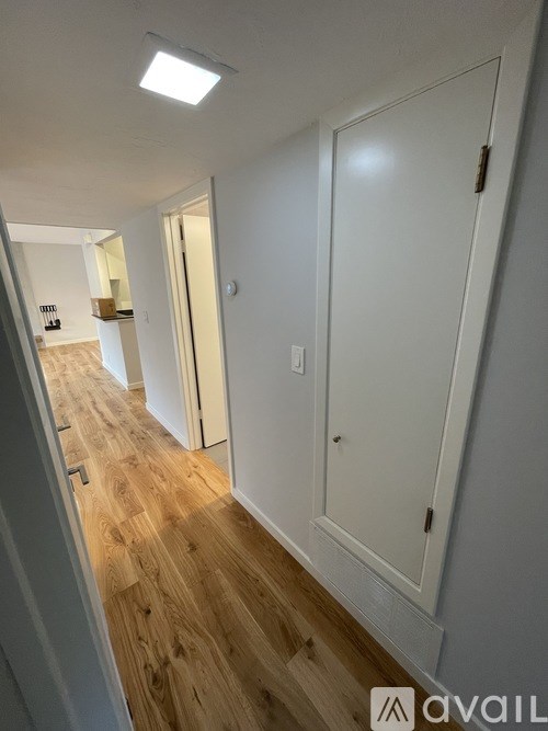 A room with wooden flooring and a window letting in natural light.