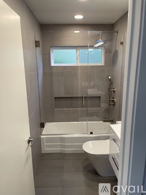 A bathroom with a white tub and toilet.