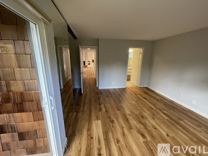 A room with wooden flooring and white walls.