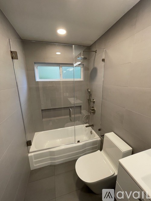 A bathroom with a white toilet, sink, and bathtub.