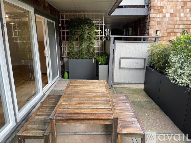 A wooden table is in the middle of a balcony.