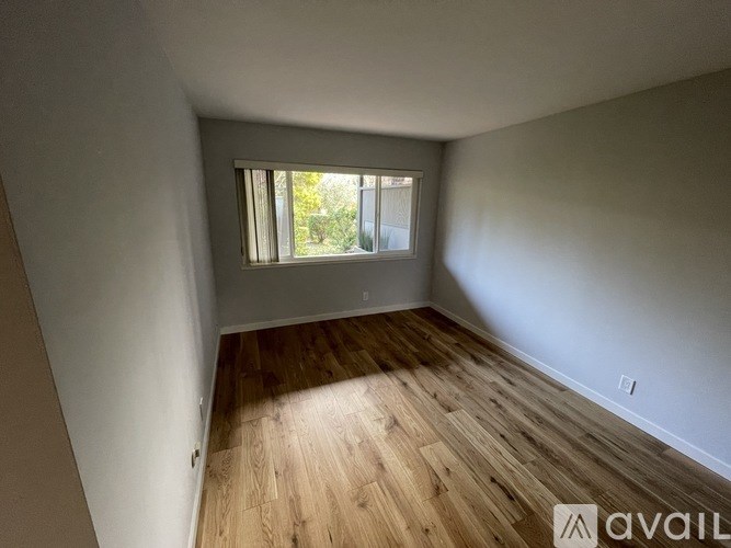 A room with wooden flooring and a window.
