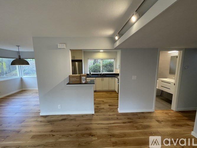 A modern kitchen with wooden floors and white walls.