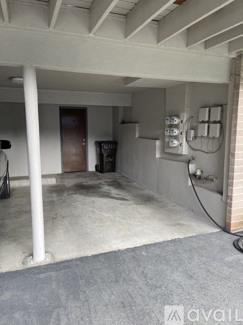 A room with a concrete floor and a door on the left side.