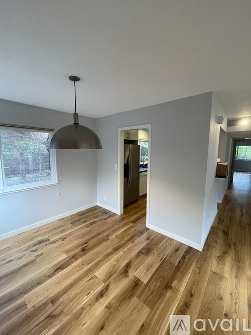 A room with wooden floors and a pendant light hanging from the ceiling.