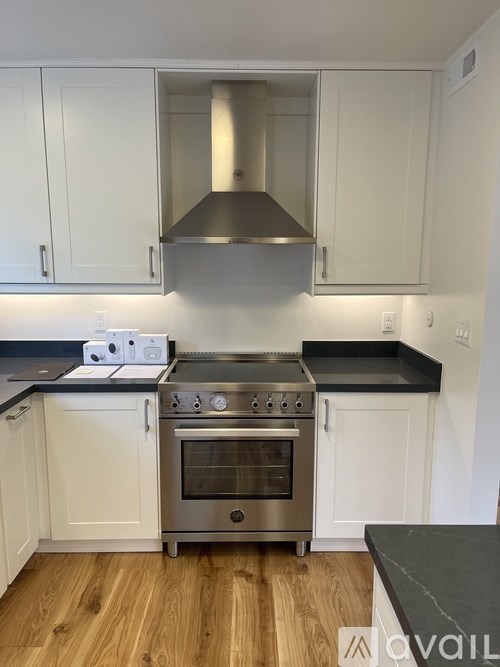 A kitchen with a stainless steel range hood and oven.