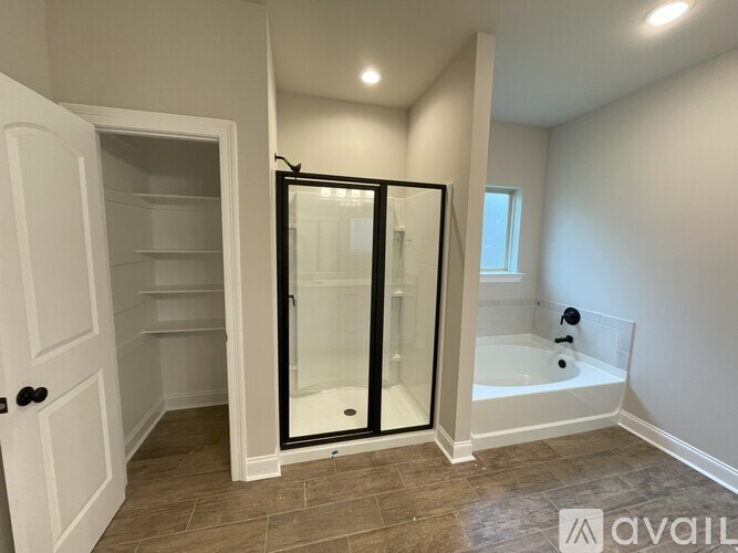 A bathroom with a walk-in shower and a white door.