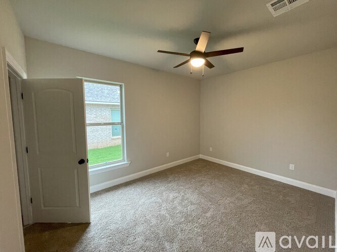 A room with a ceiling fan and a door leading to a balcony.