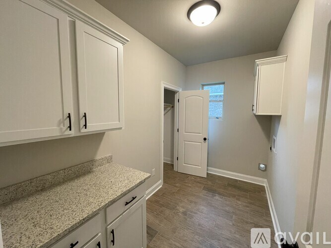 A kitchen with white cabinets and a granite countertop.