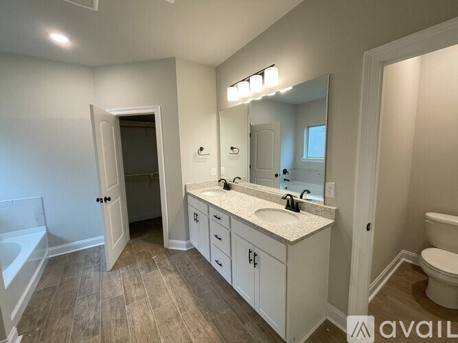 A bathroom with a white vanity, sink, and a bathtub.