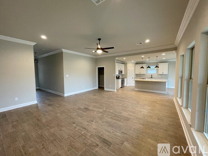 A spacious room with a ceiling fan and lighting fixtures.