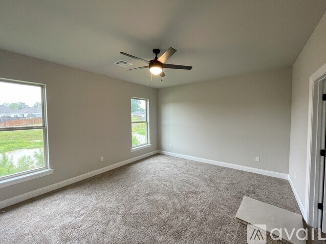 A room with a ceiling fan and carpeted floor.