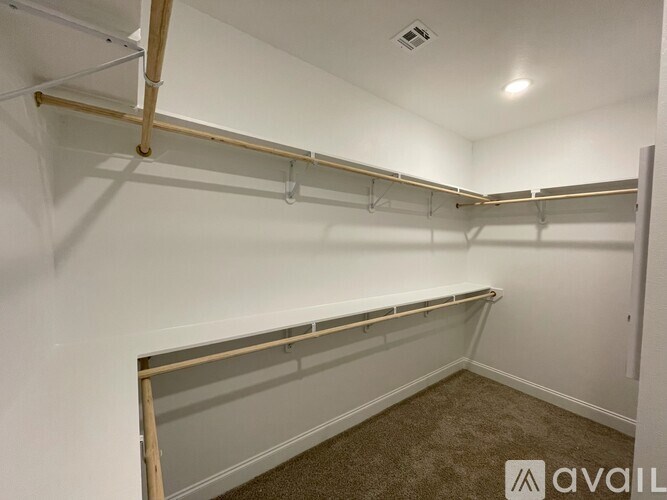 A white wall with a carpeted floor and a shelf with a pipe.