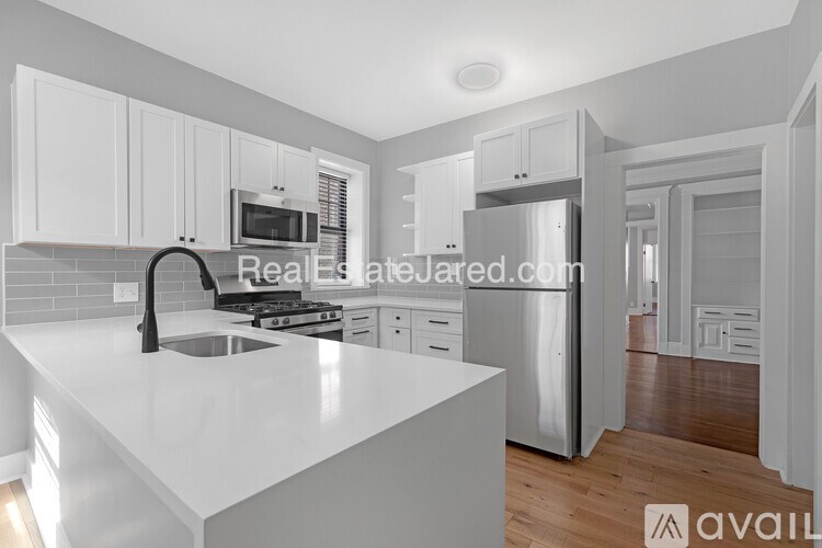 A modern kitchen with white cabinets and appliances.