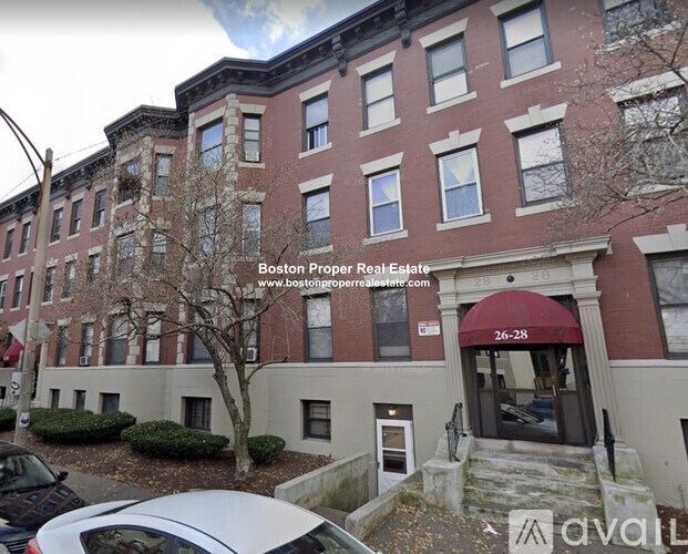 A building with a red awning and the number 26-28 on it.