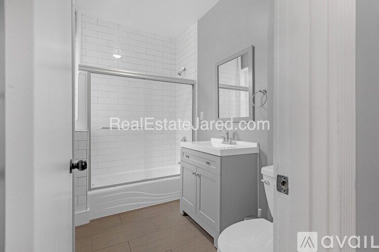 A bathroom with a white toilet, sink, and bathtub.