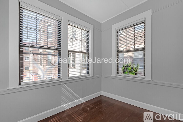 A room with two windows covered in blinds.