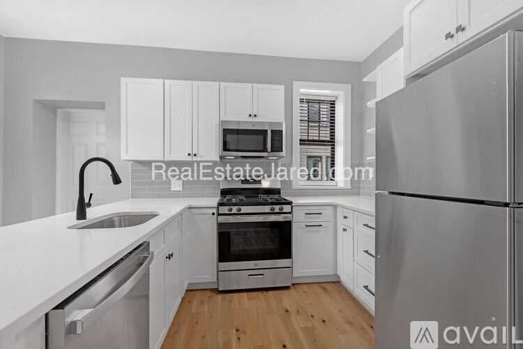 A modern kitchen with white cabinets and stainless steel appliances.