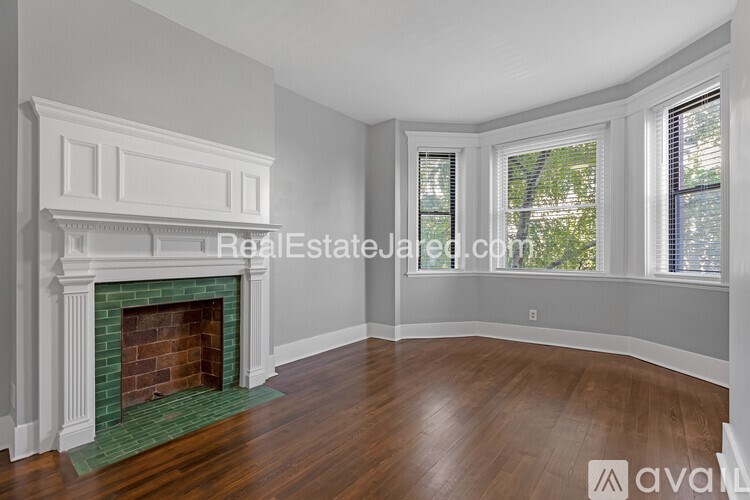 A living room with a fireplace and wood flooring.