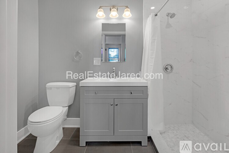 A white toilet in a bathroom with RealEstateJared.com watermark.