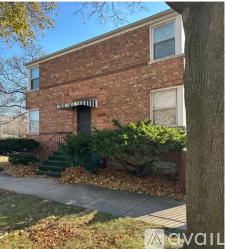 A brick house with a tree in front.