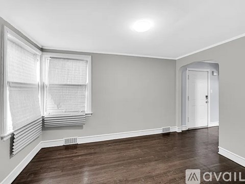A room with a window covered by blinds and a door.