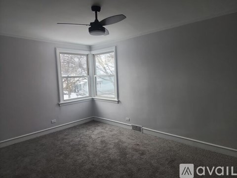 A room with a ceiling fan and a window.
