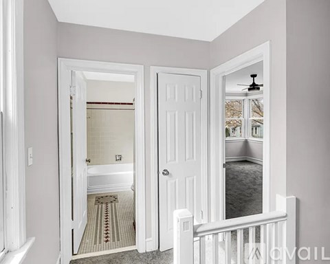 A bathroom with a white tub and a white door.