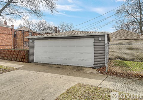 A grey garage door is closed and the garage is attached to a house.