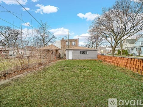 A backyard with a fence and a house in the background.