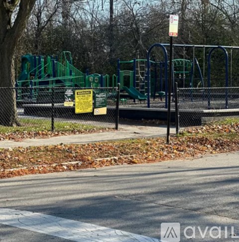 A playground with a sign that says "No Parking" is surrounded by a black fence.