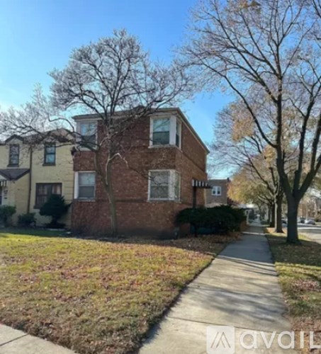 A brick house with a sidewalk in front.