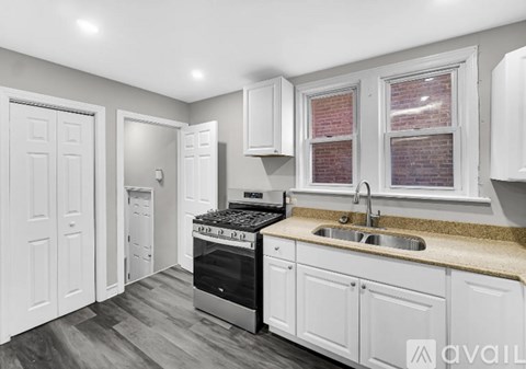 A kitchen with white cabinets and a brick window.