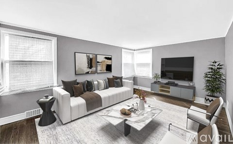 A modern living room with a white sofa, a coffee table, and a television.