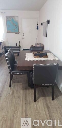A brown dining table with four chairs is in the foreground of the image.