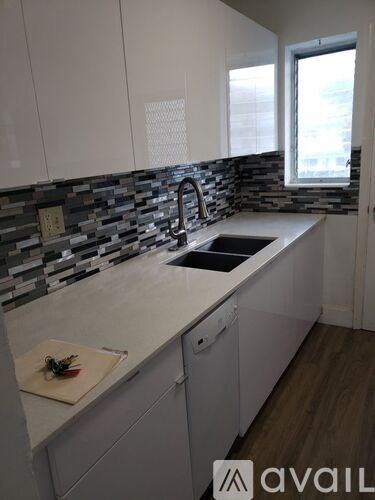 A kitchen with a white counter top and a sink.