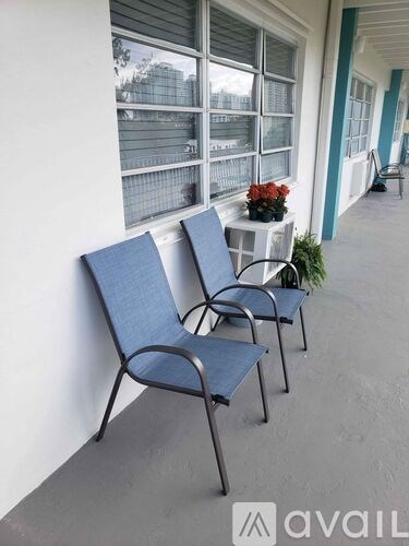 Two blue chairs are on a porch.