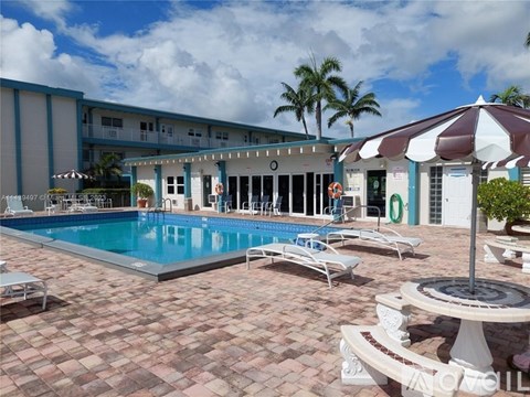 A pool area with a red and white striped umbrella.