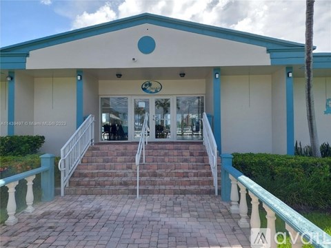A building with a blue trim and a white roof with a circular design on the top.