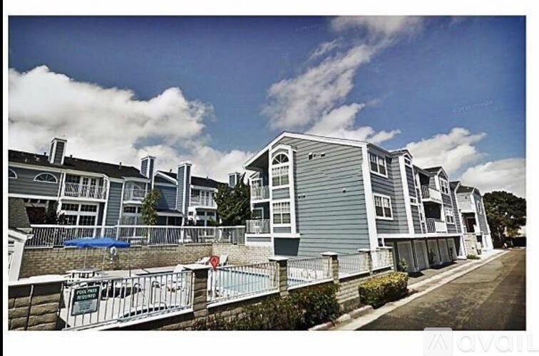 A row of houses with a blue sky and clouds in the background.