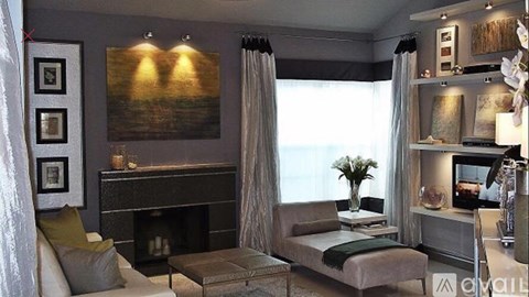 A modern living room with a fireplace and a large painting above it.