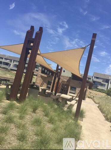 A wooden structure with a tan shade cloth over it.