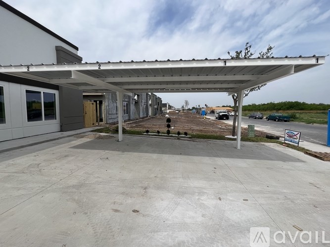 A parking lot with a building and a canopy over it.