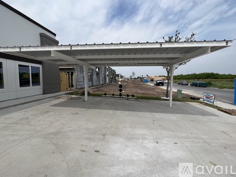 A parking lot with a building and a canopy over it.